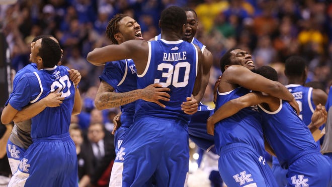 UK's James Young, #1, center, hugged teammate UK's Julius Randle, #30, ace teammate Dakari Johnson, #44, second from right, hugged Andrew Harrison, #5, after they defeated Michigan to advance to the Final Four at the Lucas Oil Stadium in Indianapolis. Mar. 30, 2014