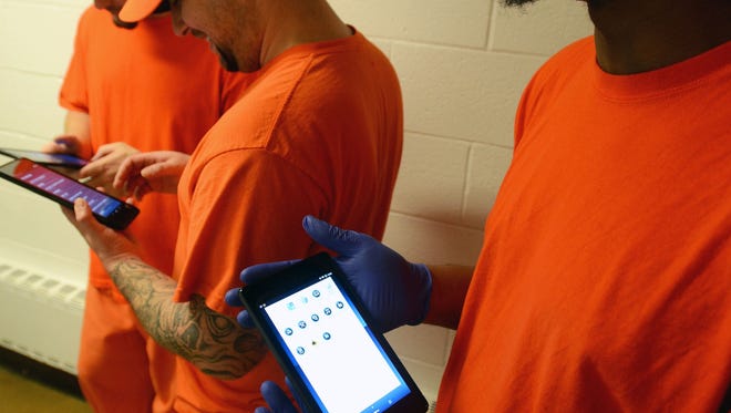 A group of inmates scroll through their new tablets Monday, Dec. 28, 2015, at the Sanilac County jail in Sandusky.