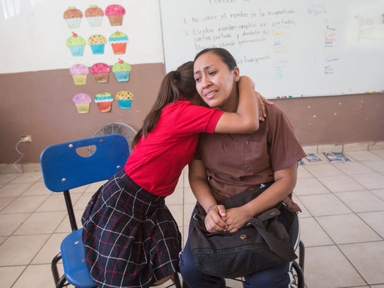 Elizabeth Rossil, 11, hugs her mother, Berenice Aguilar,