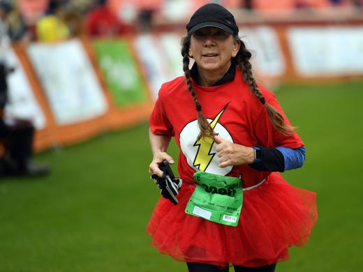 Sharon West crosses the finish line in a tutu in the