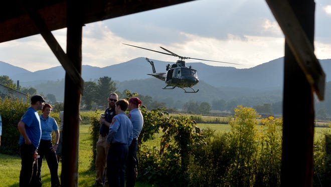 A helicopter takes off near search team members who wait for their turn to join the search for a missing pilot at the mobile command center at the Deerfield Volunteer Fire Department on Wednesday, August 27, 2014. They search for the missing pilot of an F15c fighter jet which crashed into a mountain near Elliot Knob in Augusta County.