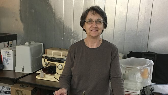 Shirley Biedenbach works on cleaning and repairing a hemming machine.  She is surrounded by sewing machines that will be for sale at the York Salvation Army Fabric Sale, June 21-23.