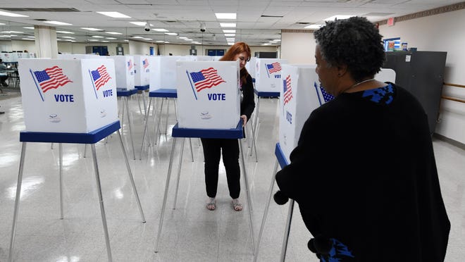 Linda Moreno (back) and Leisha Bean Clark set up voting booths at the Ezell Hester Community Center in Boynton Beach so that early voting can take place in the 2020 Presidential Preference Primary. Saturday, March 7, 2020.