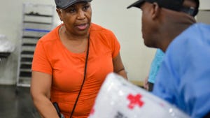 Margaret Ryan volunteers at the George R. Brown Convention Center in Houston serving food to evacuees from Hurricane Harvey, Monday, Aug. 28, 2017.  (Scott Clause/The Daily Advertiser via AP)