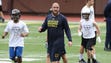 Michigan player Patrick Kugler works with high school