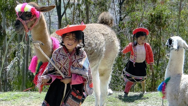 Peruvian children enjoyed posing for photos with their llamas.
