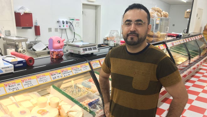 Saleh Hauter, who co-owns E&S International Market with his brother, Tony Hauter, stands in front of the deli counter. The brothers also added produce, Latin groceries and a hot food bar.