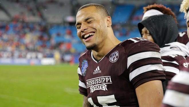Mississippi State Bulldogs quarterback Dak Prescott (15) laughs on the sidelines in the final minutes against the North Carolina State Wolfpack in the 2015 Belk Bowl at Bank of America Stadium. The Bulldogs defeated the Wolfpack 51-28.