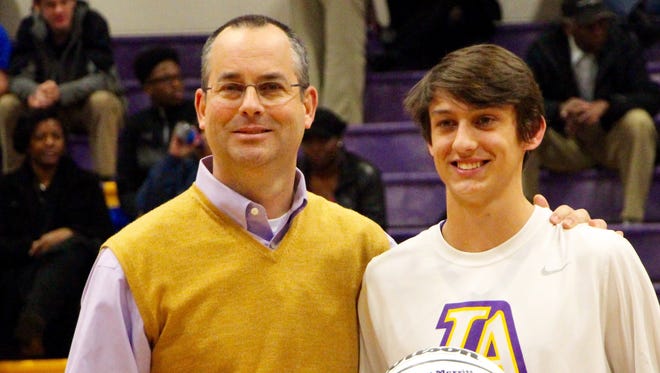 Lipscomb Academy coach Ritchie Pickens awards an honorary ball to senior John Matt Merritt in recognition of his 1,000th career point