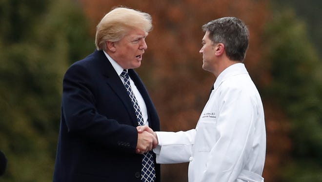 President Trump shakes hands with White House physician Dr. Ronny Jackson as he boards Marine One at Walter Reed National Military Medical Center in Bethesda, Md., Jan. 12, 2018.