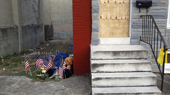 FILE - In this Nov. 27, 2017, file photo, a makeshift memorial sits in an alley where Baltimore Police Detective Sean Suiter was shot while investigating a 2016 triple homicide in Baltimore. The unsolved slaying of a homicide detective haunts the Baltimore Police Department. More than three months have passed since an on-duty attack killed Suiter a day before he was set to testify before a grand jury investigating dirty cops. Investigators have come up empty-handed. (AP Photo/Patrick Semansky, File)
