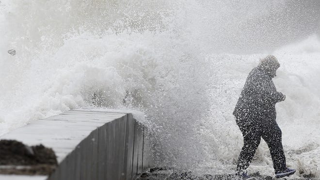 A woman gets caught by a wave as heavy seas continue to come ashore in Wintrhrop, Mass., Saturday, March 3, 2018, a day after a nor'easter pounded the Atlantic coast with hurricane-force winds and sideways rain and snow, flooding streets, grounding flights, stopping trains and leaving 1.6 million customers without power from North Carolina to Maine. (AP Photo/Michael Dwyer)
