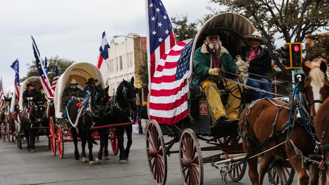 Santa Fe Trail Ride participants make their way down Concho Avenue during the San Angelo Stock Show & Rodeo parade Saturday, Feb. 3, 2018, in downtown San Angelo. 