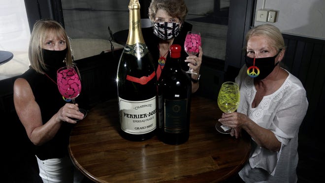 Faye Muncie (left), owner of the Hausfrau Haven boutique wine shop, enjoys a refreshment Aug. 13 with Betty Garrett (center) and Chris Hune, both with the German Village Society, at Hausfrau Haven, 769 S. Third St. in Columbus' German Village neighborhood. Garrett and Hune organized the Celebrate German Village virutal tour, which will celebrate the 1960s and feature five kitchens, serving as an abbreviated Haus und Garten Tour amid the ongoing COVID-19 coronavirus pandemic. Muncie's business is donating items for a wine giveaway that is part of the event.