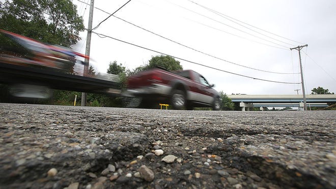 A motorist drives along a heavily traveled section of Nave Street SW near Genoa Avenue SW on Thursday in Perry Township. John Masalko, supervisor of the Perry Road Department, said leftover funds from earlier repaving projects will allow the township to repave Nave Street from Genoa Avenue to the border with Massillon later this year.