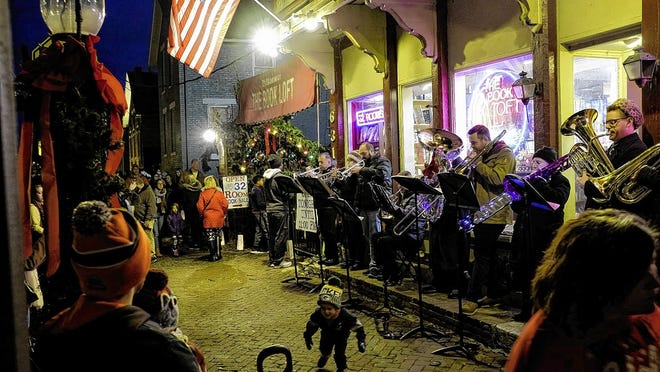 A brass band plays Christmas songs in front of the German Village Book Loft during the 2019 Village Lights event in German Village. This year, the event has been recast with a different format.