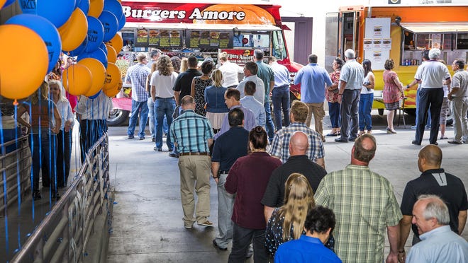 Employees of the new Gannett line up for lunch at two food trucks in the loading dock of the Arizona Republic, Monday, June 29, 2015. The trucks were brought in to celebrate the first day of the split between TEGNA and Gannett.
