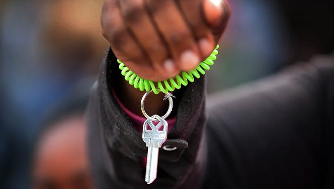 Timeka Seldon shows off her key during a dedication ceremony for her new Habitat for Humanity home in the Bearwater Park neighborhood of Uptown.
