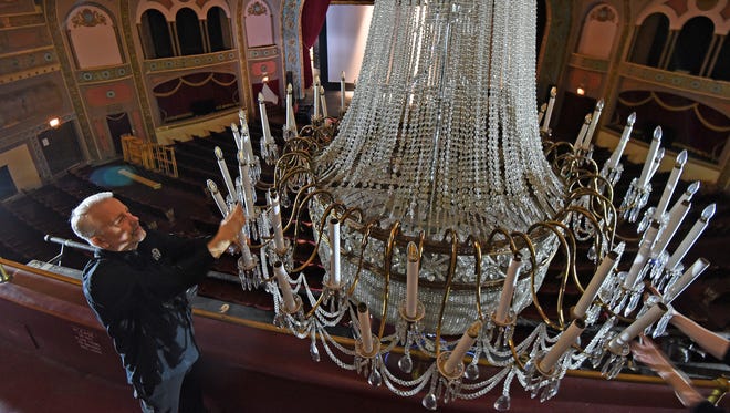Michael Miller, CEO of the Renaissance Theatre, screws in a bulb on the theater's chandelier on Tuesday afternoon. Workers are scrambling to make the venue ready for the venue's 90th anniversary upcoming events.