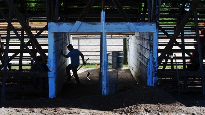 A member of the Choteau Boy Scouts Troop 51 does dirt work below the grandstands at the Augusta American Legion Rodeo Grounds on June 26.