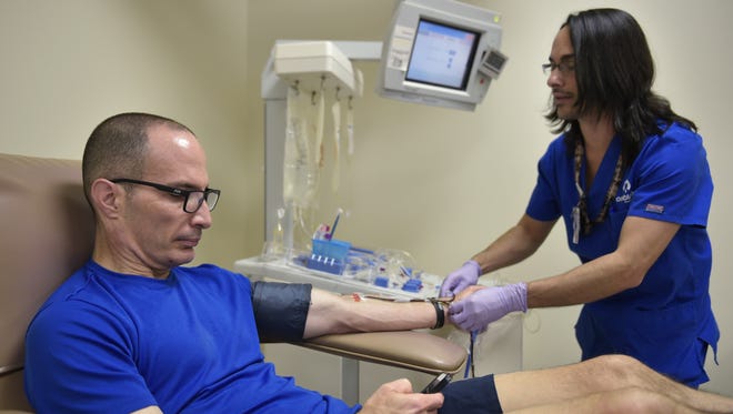 A technician prepares to take a platelet donation from Stephen Ruiz at the Oneblood blood center June 13 in Orlando, Florida.