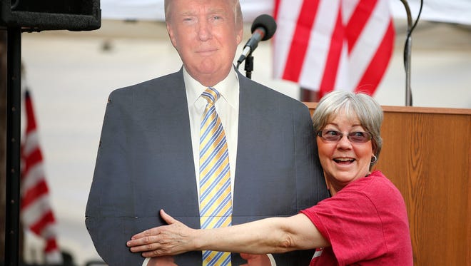 Barbara Atkinson, of Gilbert, gives President Donald Trump a little love during a Pro-Trump rally at the state capitol in Phoenix on March 4, 2017. 
