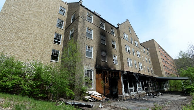 A daylight view Tuesday, April 19, 2016, of the damage caused by a fire intentionally set to a wooden porch on the side of Jenkins Hall at the former Reid Hospital building on Chester Boulevard in Richmond.