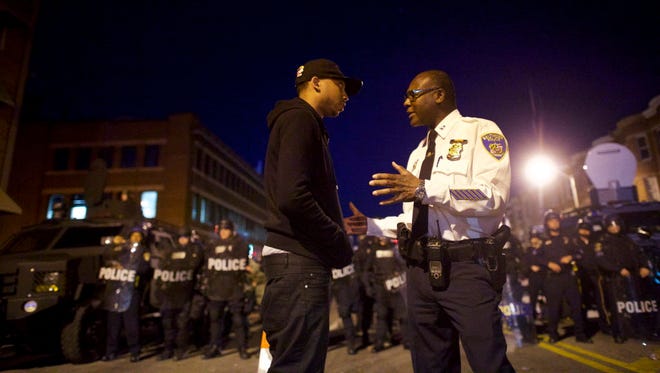A Baltimore police captain tries to calm a protester Tuesday night.