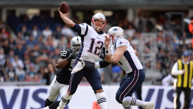 New England Patriots quarterback Tom Brady (12) throws a pass during the first quarter against the Oakland Raiders at Estadio Azteca.