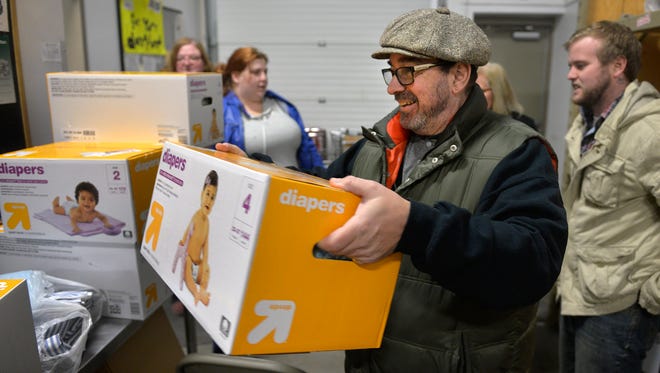 Operation: Baby New Year coalition member Ric Studer carries a box of diapers to a shelf at Catholic Charities Emergency Services on Wednesday, Dec. 16 in St. Cloud. The coalition is hoping to provide 100,000 donated diapers to various relief agencies in the area by Jan. 1. The group dropped off 972 diapers at Catholic Charities on Wednesday.