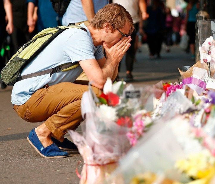 People stop and look at flowers and tributes in the Finsbury Park area of north London following a van attack on pedestrians on June 19.