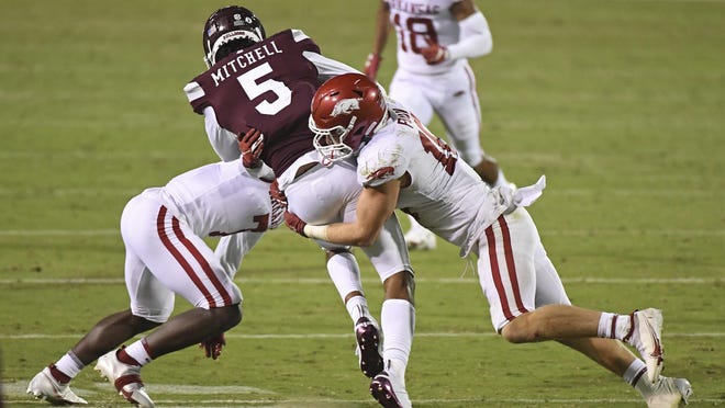 Arkansas defensive back Joe Foucha (7) and linebacker Bumper Pool (10) tackle Mississippi State wide receiver Osirus Mitchell (5) during the second half of an NCAA college football game in Starkville, Miss., Saturday, Oct. 3, 2020. Arkansas won 21-14.