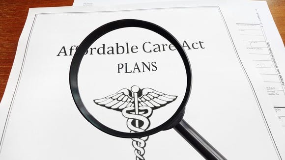 A magnifying glass held over an Affordable Care Act plan.