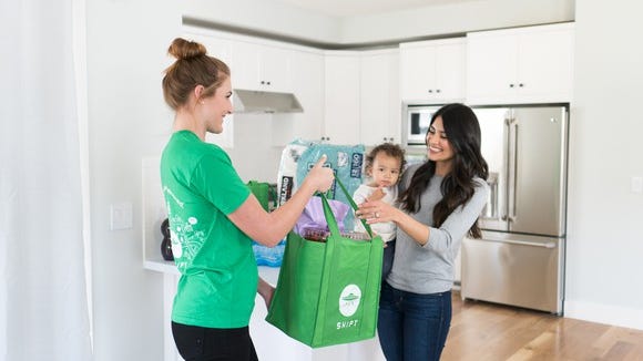A Shipt shopper delivers same-day groceries at a customer's home