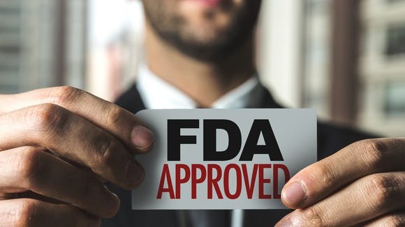 Man holding card with "FDA approved" printed on it