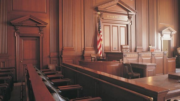Wood-paneled courtroom with view of front as seen from far end of jury box.