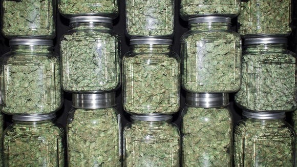 Jars of dried cannabis stacked on top of each other.