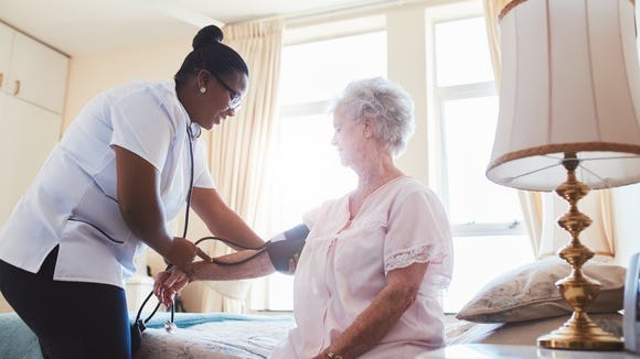 Nurse checking on senior female patients.