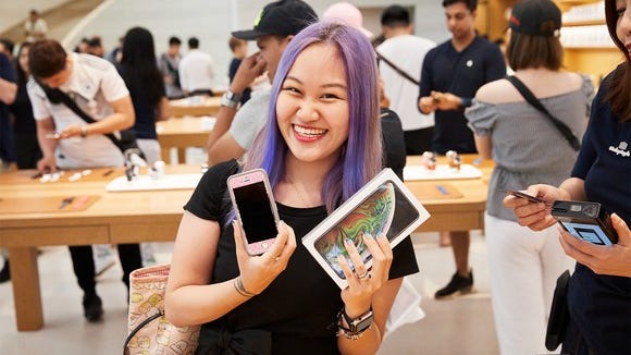 Woman holding up a new iPhone XS Max