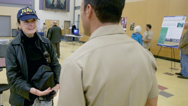 Dr. Terry Zumwalt , of Bainbridge Island, talks with a Navy special operations service member during a meeting Tuesday at North Kitsap High School. The Navy plans to expand special operations training in the Northwest.