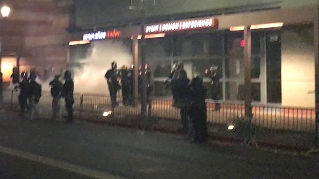 Video appears to show demonstrators throw canisters at police