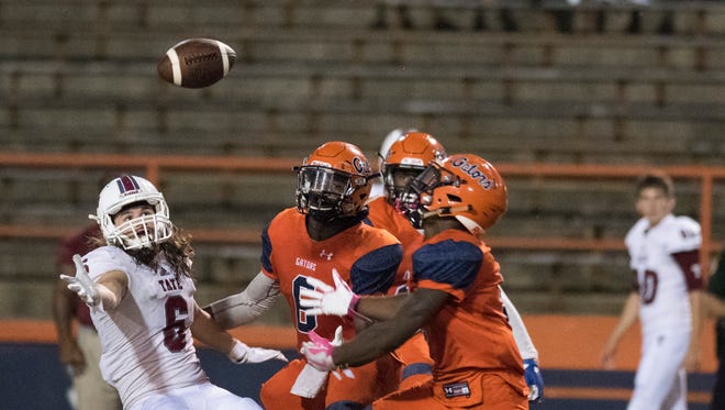 Tate High receiver, Dawson Foster, (No. 6) and Escambia High defensive backs, Te'Keshuan Lewis, (No. 6) and Patrick Sanders,(No. 9) battle for a tipped pass during the Gator's first home game of the season Friday night.