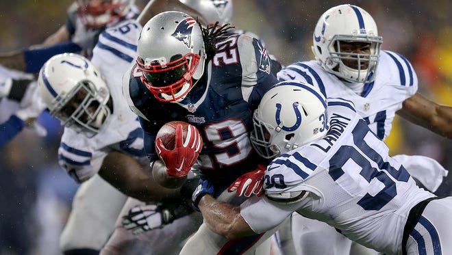 New England Patriots running back LeGarrette Blount (29) bounces off of Indianapolis Colts free safety LaRon Landry (30),right, as he eyes the end zone in the third quarter. The Indianapolis Colts play the New England Patriots in the AFC Championship game Sunday, January 18, 2015, at Gillette Stadium in Foxborough MA.