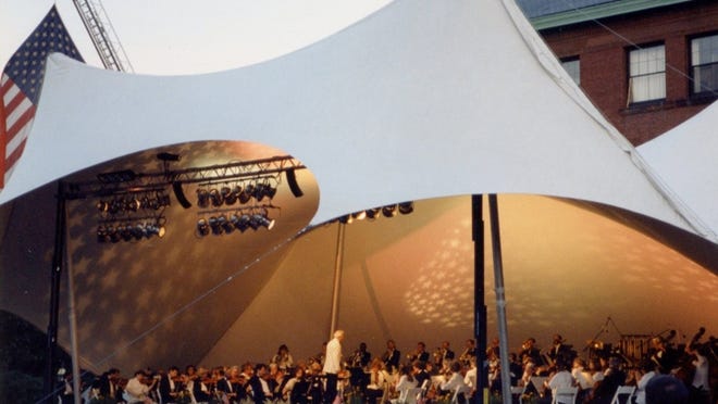 Royston Nash conducts the Cape Cod Symphony Orchestra before a crowd of 5,000 at the Hyannis Village Green during an Independence Day weekend concert in 1996.