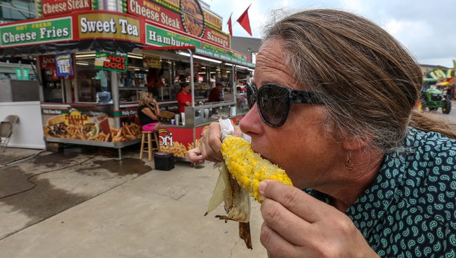 Vickie Senn, of PRP, dives into an ear of corn at the Kentucky State Fair on Friday morning.August 19, 2016