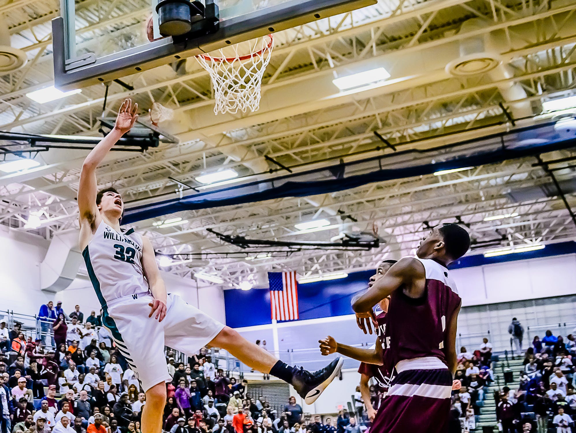 Sean Cobb ,left, of Williamston lays the ball in over River Rouge defenders to put Williamston up 50-49 with 1:15 remaining in their Class B state quarterfinal game Tuesday March 21, 2017 at Chelsea High School in Chelsea. KEVIN W. FOWLER PHOTO