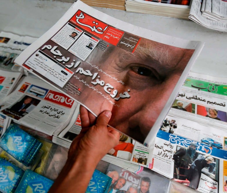 An Iranian displays the front page of a newspaper in Tehran on May 9, a day after President Trump announced he is pulling the U.S. out of the nuclear accord with Tehran and world powers.