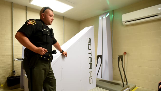 Coshocton County Sheriff's Deputy Dustin Mullinnex talks to an innate he transported from court about her potentially going to rehab while waiting for her to be scanned before entering the jail. The body scanner ensures no contraband makes it in the jail.