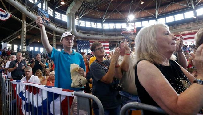 Audience members react as Republican presidential candidate Donald Trump speaks at Joni's Roast and Ride, a fundraiser for a PAC, at the Iowa State Fairgrounds, in Des Moines, Iowa.