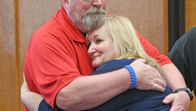 Pam Myers and her husband Dale share an embrace Thursday afternoon during her retirement party.